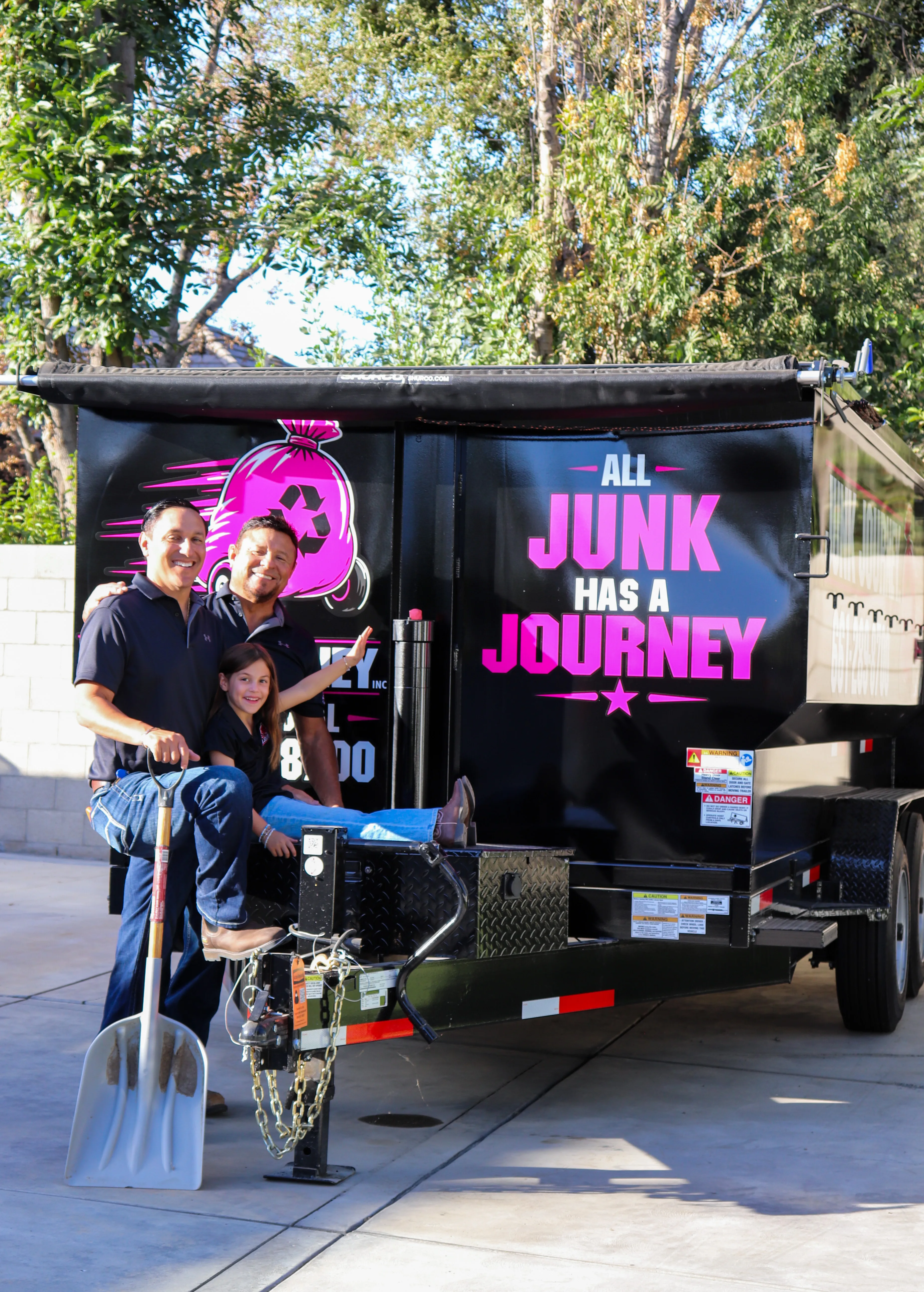 The Junk Journey family beside their branded removal trailer